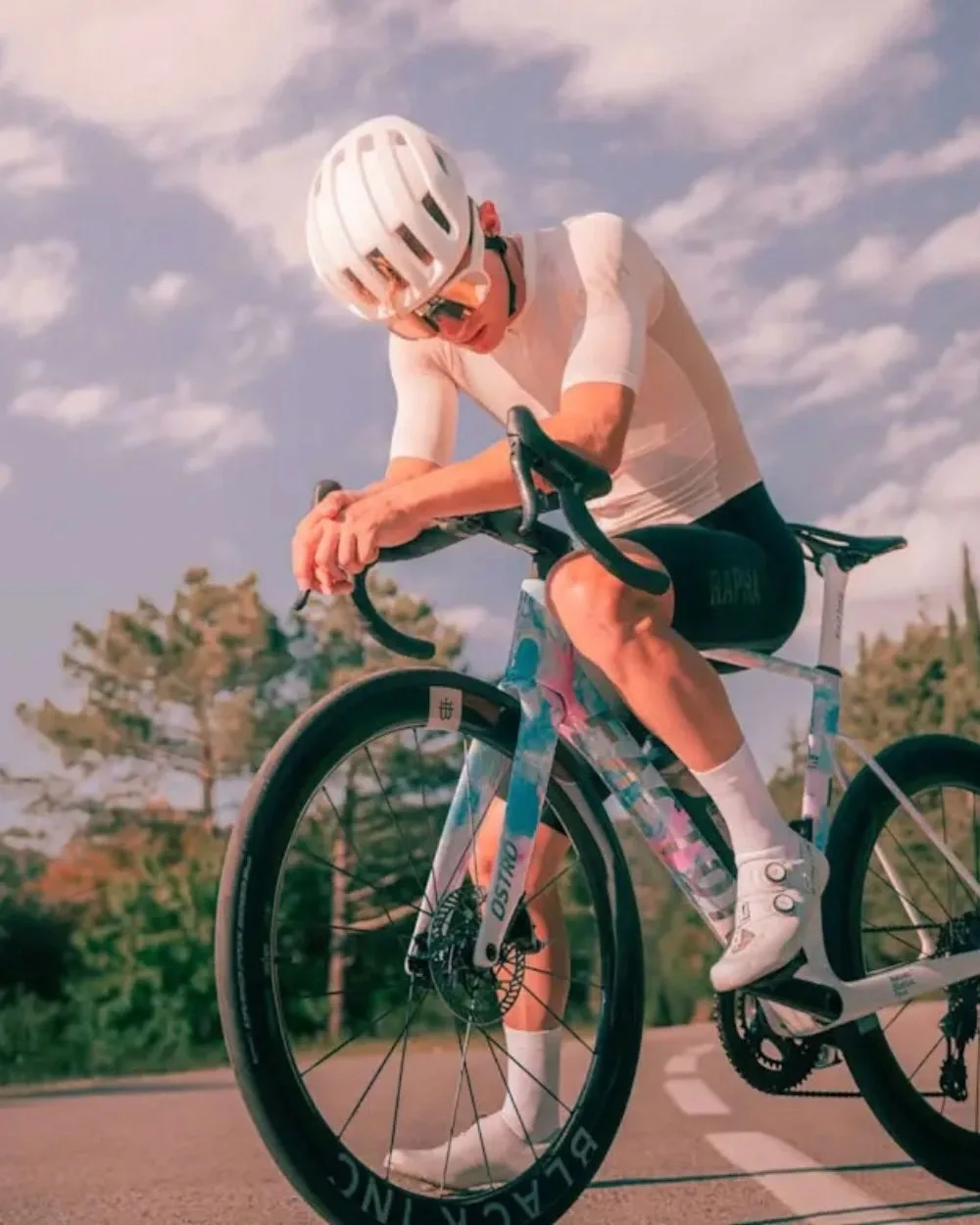Biker in salto con la mountain bike in un bosco di pini